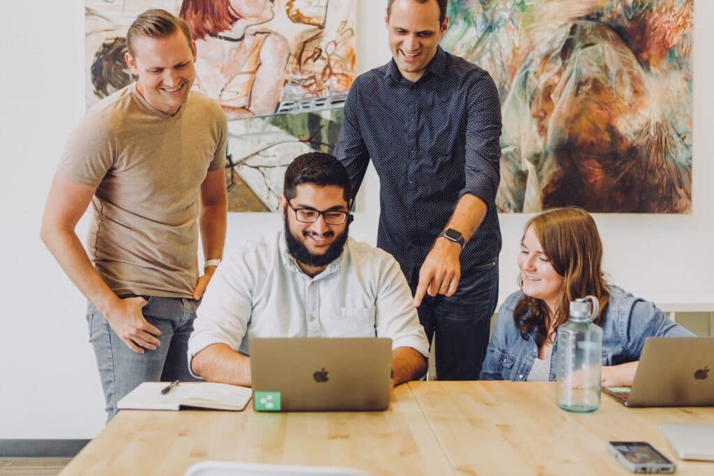 Happy people in office using desk booking software